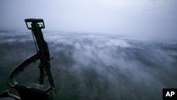 FILE - Seen from an Army helicopter, clouds cover the jungle of San Jose del Guaviare, Colombia, at dusk Friday, March 22, 2019. Colombia is the largest producer of cocaine and the surface of coca fields has risen steadily in the last few years.
