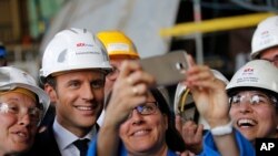 French President Emmanuel Macron poses for selfies as he visits the MSC Meraviglia cruise ship at the STX shipyard site in Saint-Nazaire, western France, May 31, 2017. 