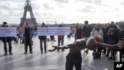 FILE - Dancer Alioune Diagne performs in Paris, calling for the release of French scientists Fariba Adelkhah and Roland Marchal in Iran, Feb. 11, 2020. An Iranian court sentenced Adelkhah to six years in prison, her lawyer said May 16, 2020. 