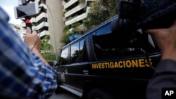 Un auto de la policía militar (DGCIM) sale del edificio donde vive la familia de Juan José Márquez en Caracas, Venezuela, el 20 de febrero de 2020.