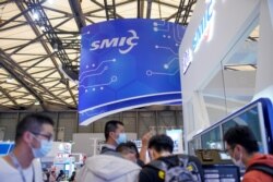 FILE - People visit a booth of Semiconductor Manufacturing International Corp. at the China International Semiconductor Expo following the coronavirus disease outbreak in Shanghai, Oct. 14, 2020.