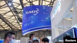 FILE - People visit a booth of Semiconductor Manufacturing International Corp. at the China International Semiconductor Expo in Shanghai, China, Oct. 14, 2020.