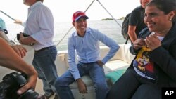 Juan Guaidó, opposition leader and self-proclaimed interim president of Venezuela, sits on a boat with staff members before crossing Maracaibo Lake to reach the town of Cabimas, Venezuela where he will lead a rally, April 14, 2019.