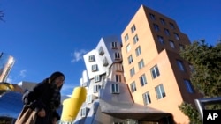 FILE - A person walks near buildings, Dec. 17, 2024, on the campus of Massachusetts Institute of Technology in Cambridge, Mass. 