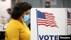 A woman fills in a ballot for the 2020 U.S presidential election in Fairfax, Virginia, November 3, 2020. 