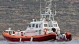 Italian Coast Guard personnel load a body bag on their patrol boat off Lampedusa island, Oct. 8, 2013. 