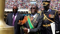 Zimbabwe's President Robert Mugabe, center, prepares to light the independence flame during Zimbabwe's 33rd independence celebrations in Harare, Apr. 18, 2013.