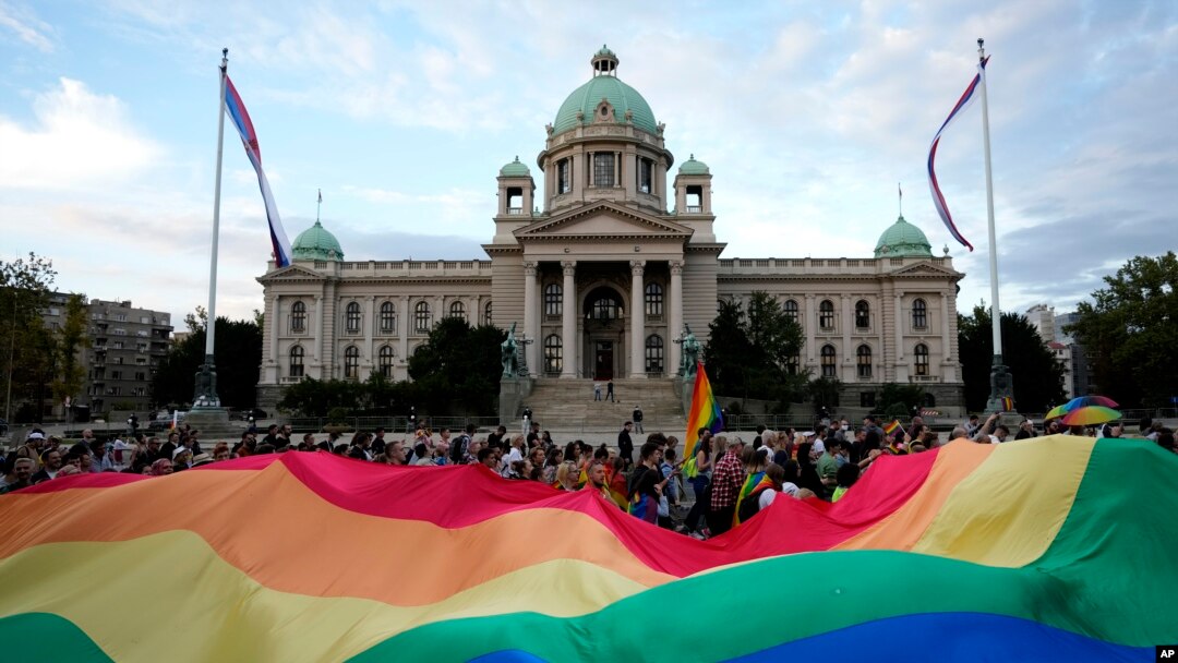 Učesnici Belgrejd prajda nose veliku zastavu duginih boja ispred zdanja Doma Narodne skupštine Republike Srbije, tokom protesne šetnje, 18. septembra 2021. (Foto: AP, Darko Vojinović)