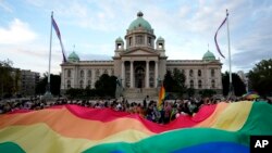 Učesnici Belgrejd prajda nose veliku zastavu duginih boja ispred zdanja Doma Narodne skupštine Republike Srbije, tokom protesne šetnje, 18. septembra 2021. (Foto: AP, Darko Vojinović)