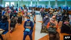 Ibu-ibu menunggu giliran vaksinasi virus corona COVID-19 di Surabaya, 19 Agustus 2021, dalam rangka percepatan program vaksinasi termasuk untuk ibu hamil. (Foto: JUNI KRISWANTO/AFP)