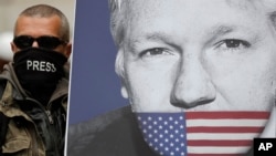 Seorang Julian Assange, dengan poster pendiri WikiLeaks, bergabung bersama para pengunjuk rasa lainnya untuk memblokir jalan utama di depan Pengadilan Westminster di London, 2 Mei 2019.