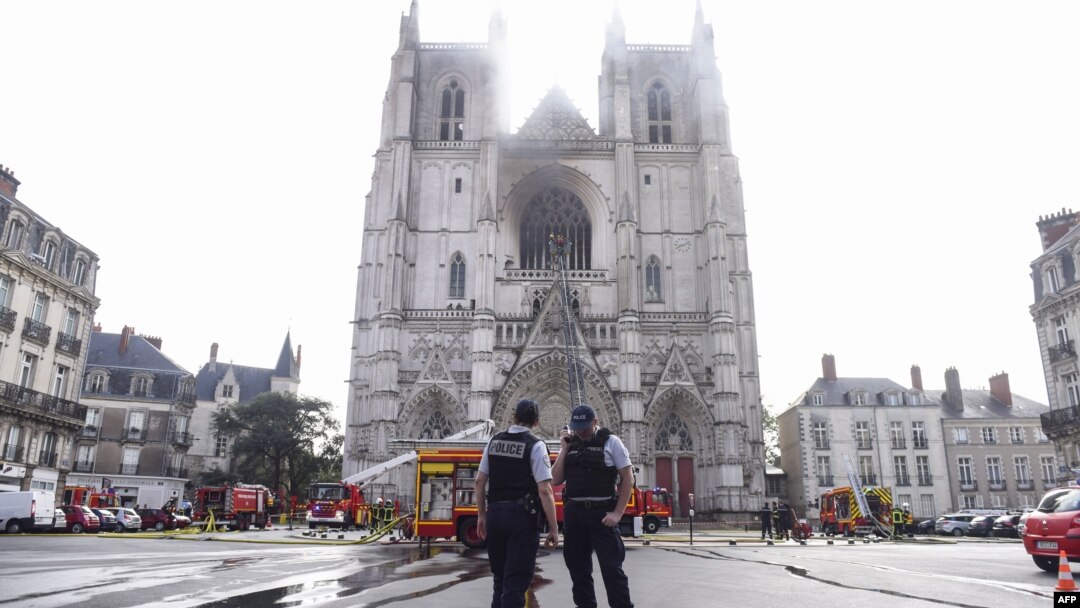 Polisi berjaga sementara para petugas pemadam kebakaran memadamkan api di Katedral Santo Pierre-dan-Santo Paul di Nantes, barat Perancis, 18 Juli 2020. 