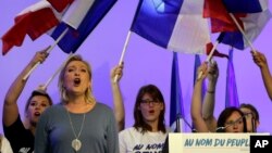 FILE - France's far-right National Front president Marine Le Pen sings the French National anthem "La Marseillaise" after her speech in Frejus, southern France, Sept. 18, 2016.