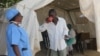 A medical staff member (left) administers oral rehydrating solution to a cholera patient to replace fluids he lost through diarrhea, in Harare, Zimbabwe, Sept. 12, 2018, (C. Mavhunga/VOA) 