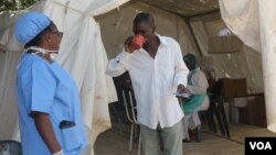 Umongikazi upha isigulane umuthi wokwelapha icholera.