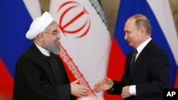 ប្រធានាធិបតី​រុស្ស៊ី Vladimir Putin ចាប់​ដៃ​ជាមួយប្រធានាធិបតី​អ៊ីរ៉ង់ Hassan Rouhani ក្នុង​សន្និសីទ​កាសែត​រួម​គ្នា​មួយ​នៅ​វិមាន​ក្រឹមឡាំង ក្នុង​ទីក្រុង​មូស្គូ កាល​ពី​ថ្ងៃទី​២៨ ខែ​មីនា។