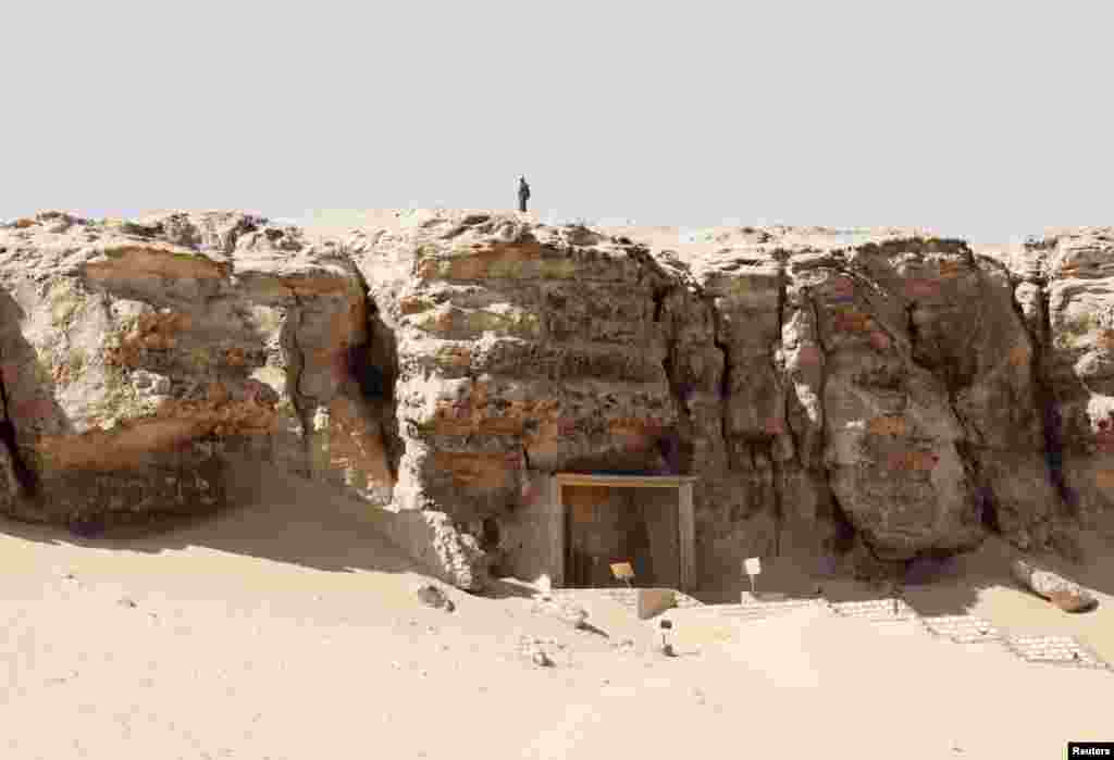 A member of security personnel stands atop a cliff as he guards the area during the presentation of a new discovery at Tuna el-Gebel archaeological site in Minya Governorate, Egypt, Feb. 2, 2019.