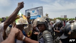 Malian riot police keep supporters away from the vehicle of t Assimi Goita, head of Mali's transitional government, as he returns from Accra after a meeting with the ECOWAS (Economic Community of West African States) representatives on May 31, 2021.