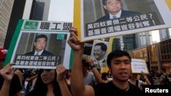 Pro-democracy protesters carrying portraits of Hong Kong Chief Executive Leung Chun-ying march to his residence in Hong Kong, Oct. 22, 2014.