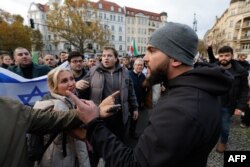 FILE - A man (R) is confronted by demonstrators after having spat into the crowd during a march and rally in support of Israel and the hostages being held by Palestinian militant group Hamas, in Berlin, Germany on November 5, 2023.