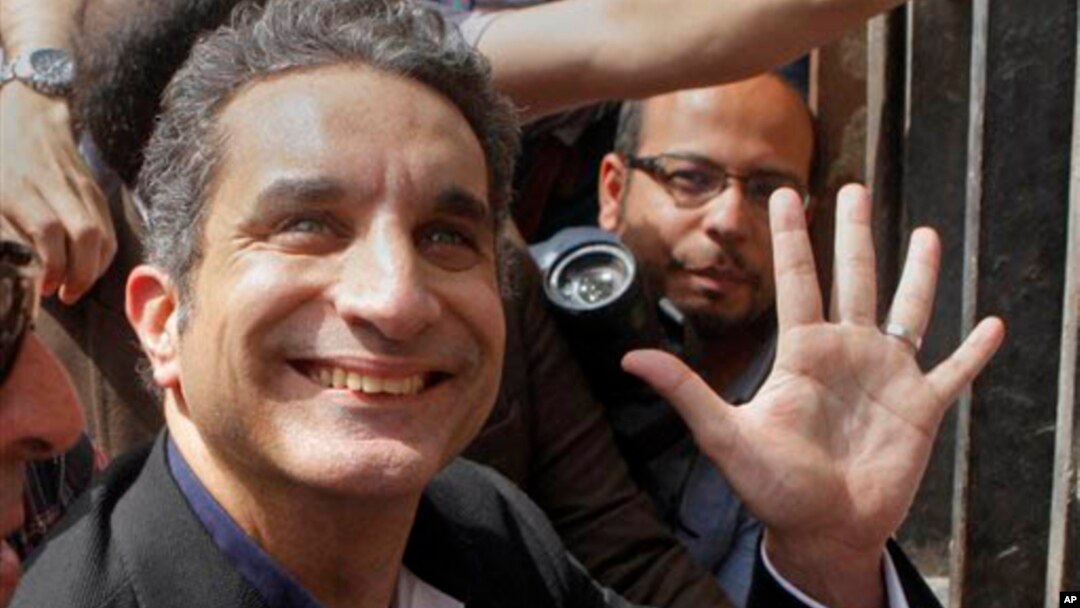 Bassem Youssef, Egyptian TV satirist, waves to supporters in Cairo before talks with authorities about charges he insulted Islam and the nation's president, March 31, 2013.
