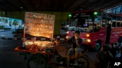 A mobile food vender waits for customers in Bangkok, Thailand, June 9, 2020. Thai government continues to ease restrictions on businesses that were imposed weeks ago to combat the spread of COVID-19.