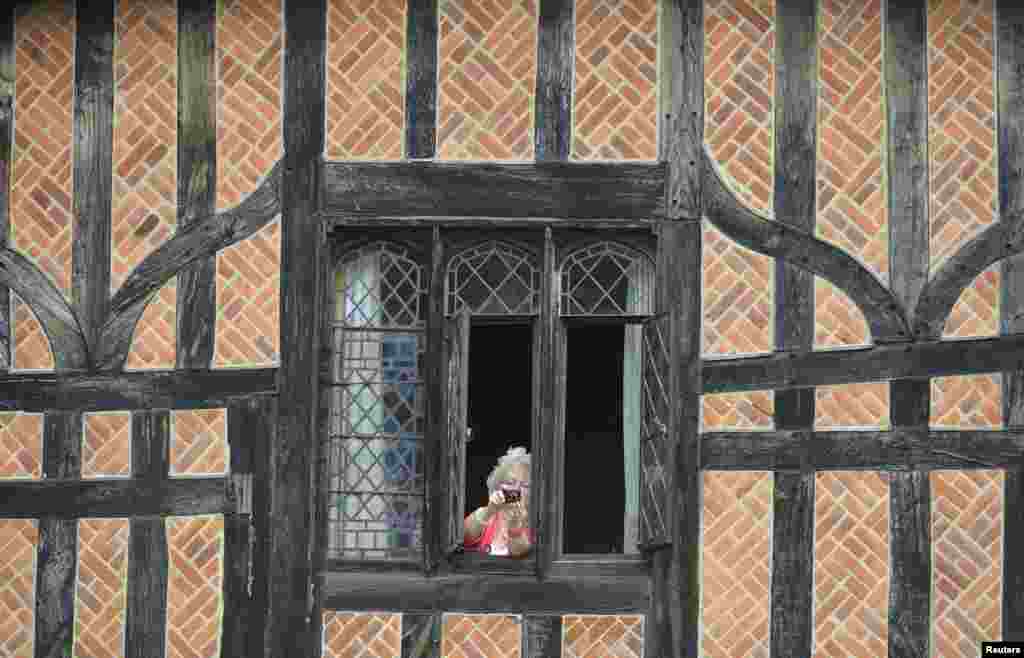 A woman takes pictures from a cottage inside Windsor Castle as Britain&#39;s royal family attend the Order of the Garter procession and installation service at Windsor Castle in southern England.