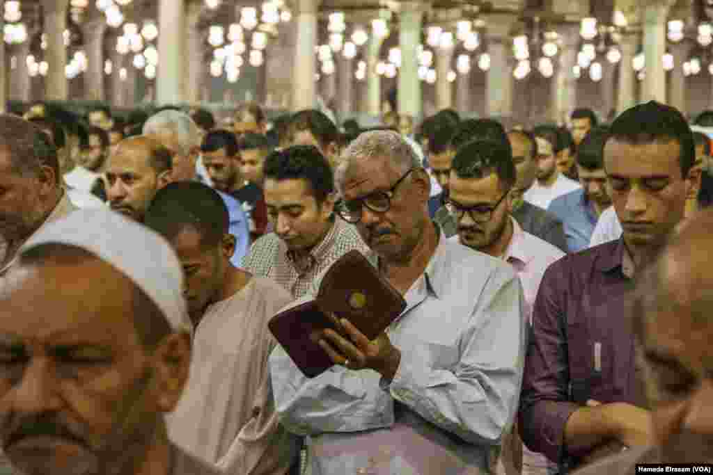 A muslim man attends the prayers while he follows the Imam reading in his Quran in Amru Ebn Alaas mosque in old Cairo, Egypt, June 21, 2017. (Hamada Elrasam/VOA)