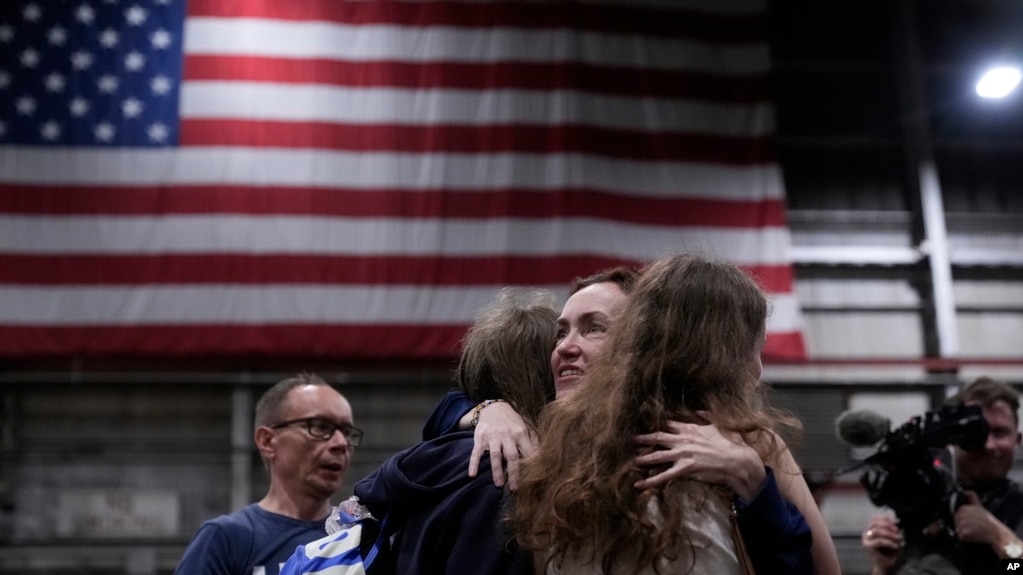 Alsu Kurmasheva, tercera desde la izquierda, es recibida por miembros de su familia después de llegar a Kelly Field después de ser liberada por Rusia, el viernes 2 de agosto de 2024, en San Antonio. (Foto AP/Eric Gay)