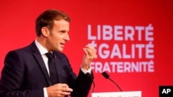 French President Emmanuel Macron delivers a speech to present his strategy to fight radical Muslim separatism, in Les Mureaux, outside Paris, Oct. 2, 2020. 