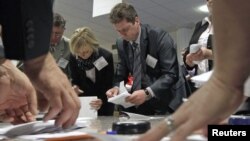 Members of the local electoral commission count ballots at a polling station after the parliamentary election in Minsk, Belarus, September 23, 2012.