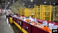 Pegawai layanan Pos Amerika serikat (USPS) tampak menyortir surat-surat yang masuk ke Pusat Pemrosesan dan Distribusi Los Angeles pada 30 November 2022. (Foto: AFP/Frederic J. Brown)