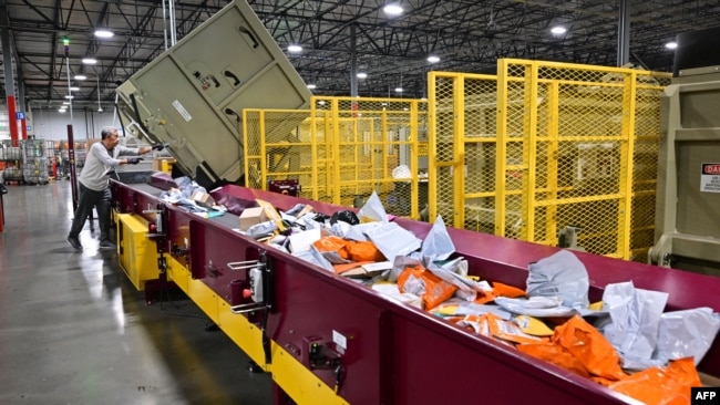 Pegawai layanan Pos Amerika serikat (USPS) tampak menyortir surat-surat yang masuk ke Pusat Pemrosesan dan Distribusi Los Angeles pada 30 November 2022. (Foto: AFP/Frederic J. Brown)