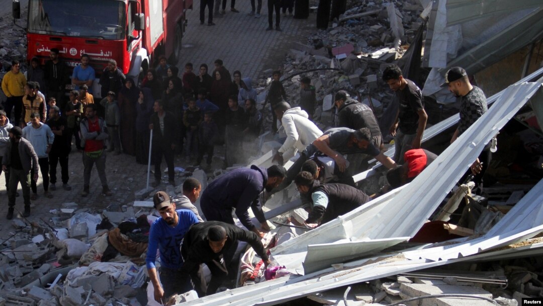 Palestinos, incluidos rescatistas, buscan víctimas en el lugar de un ataque israelí contra una casa, en la ciudad de Gaza, el 18 de noviembre de 2024. (REUTERS/Mahmoud Issa)