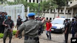 A U.N. staff member directs an ambulance after a bomb blast that ripped through the United Nations offices in the Nigerian capital of Abuja.