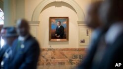 FILE - A portrait of the Rev. Martin Luther King Jr. hangs in a hallway of the Georgia State Capitol in Atlanta during a ceremony paying tribute to King, Jan. 17, 2014