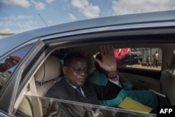 FILE - Cameroonian opposition leader Maurice Kamto (L) sits in the back of a car as he is driven away on Oct. 5, 2019, the day of his release from prison in Yaounde.
