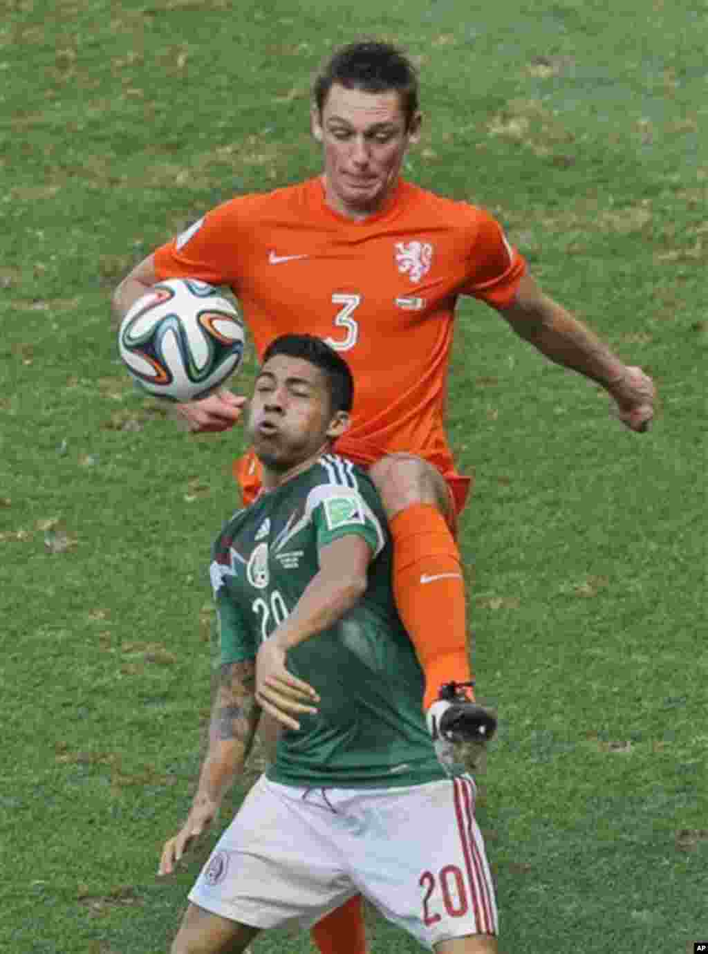 Netherlands' Stefan de Vrij, right, and Mexico's Javier Aquino challenge for the ball during the World Cup round of 16 soccer match between the Netherlands and Mexico at the Arena Castelao in Fortaleza, Brazil, Sunday, June 29, 2014. (AP Photo/Themba Hade