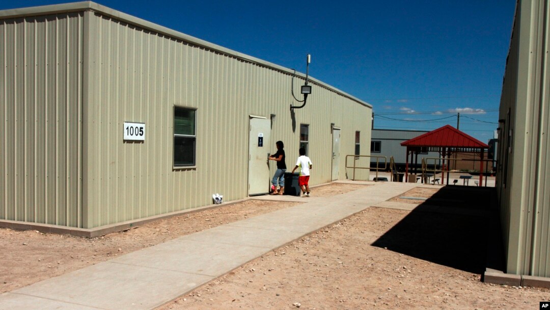 Dua orang tampak memasuki pusat penanganan imigran tak berdukumen, khususnya untuk para ibu dan anak, di Artesia, New Mexico, 10/9/2014.