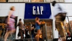 People pass by the GAP clothing retail store in Manhattan, New York, U.S., Aug. 15, 2016. 