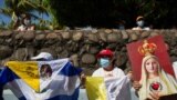 Peregrinos sostienen banderas mientras participan en un evento de la Virgen de Fátima el 13 de agosto de 2022 REUTERS/Maynor Valenzuela
