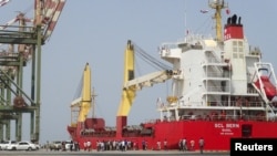 Yemeni officials gather near a ship carrying food aid at Yemen's southern port of Aden, July 21, 2015.