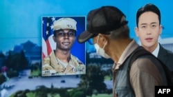 Un hombre pasa el 16 de agosto de 2023 frente a una pantalla de televisión en Seúl, Corea del Sur, que informa sobre el soldado estadounidense que cruzó hacia Corea del Norte hace un mes.