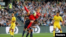 Benjamin Lecomte, gardien de Montpellier, saute et capte un ballon devant Marquinhos et Lucas Moura de Paris Saint-Germain, au stade de la Mosson, Montpellier, France, 23 septembre 2017. 