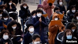Buddhist believers pray for their children’s success in the college entrance examinations amid the coronavirus disease (COVID-19) pandemic, at a Buddhist temple in Seoul, South Korea, Dec. 2, 2020. 
