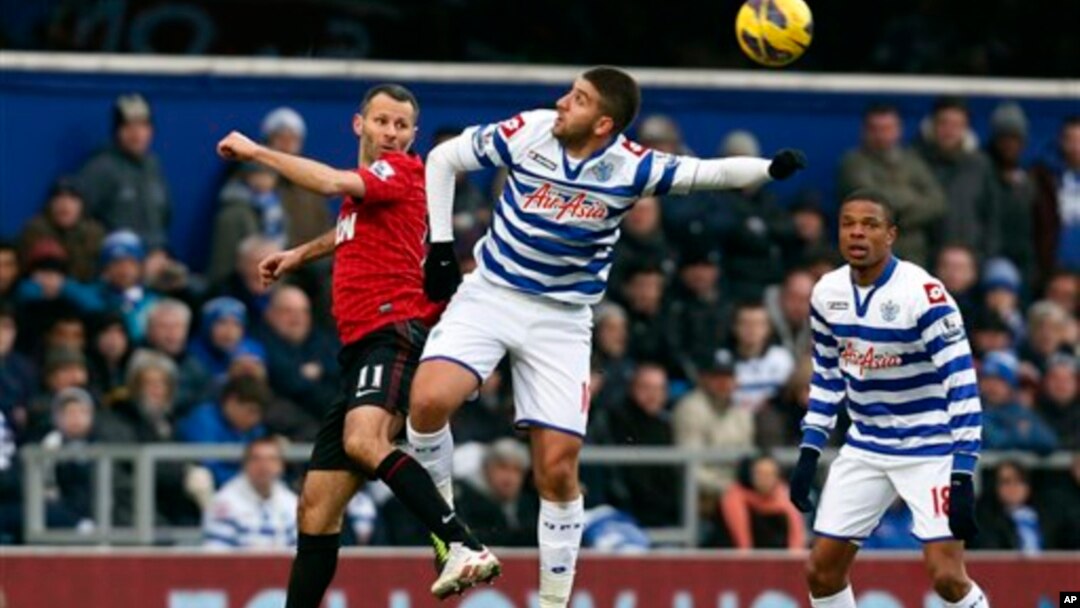 Ryan Giggs dari Manchester United (kiri) berebut bola dengan Adel Taarabt dari Queens Park Rangers (tengah) dalam pertandingan Liga Premier di lapangan Loftus Road di London (23/2).