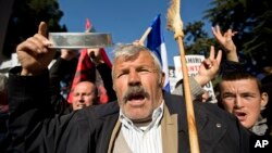 FILE - Supporters of Albania's opposition shout slogans as they participate in an anti-government march, in Tirana, Jan. 27, 2018. Critics accused the Cabinet of having links to organized crime and called for its resignation. 