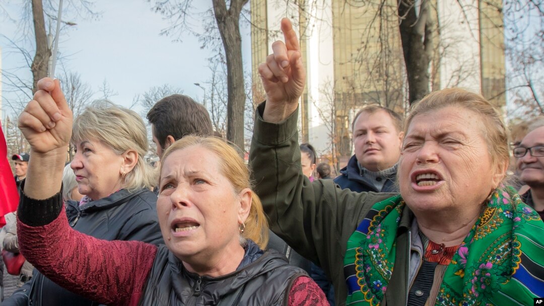 Supporters of the government shout slogans outside Moldova's parliament during a rally in Chisinau, Moldova, Nov. 12, 2019. 