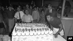 Muhammad Ali meniup lilin di atas kue ulang tahunnya yang ke-25, di Houston. (AP/Ed Kolenovsky).