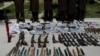 FILE - Weapons and ammunition seized are presented to the media along with insurgents suspected of being from the Haqqani network at the National Directorate of Security (NDS) headquarters in Kabul, May 30, 2013.